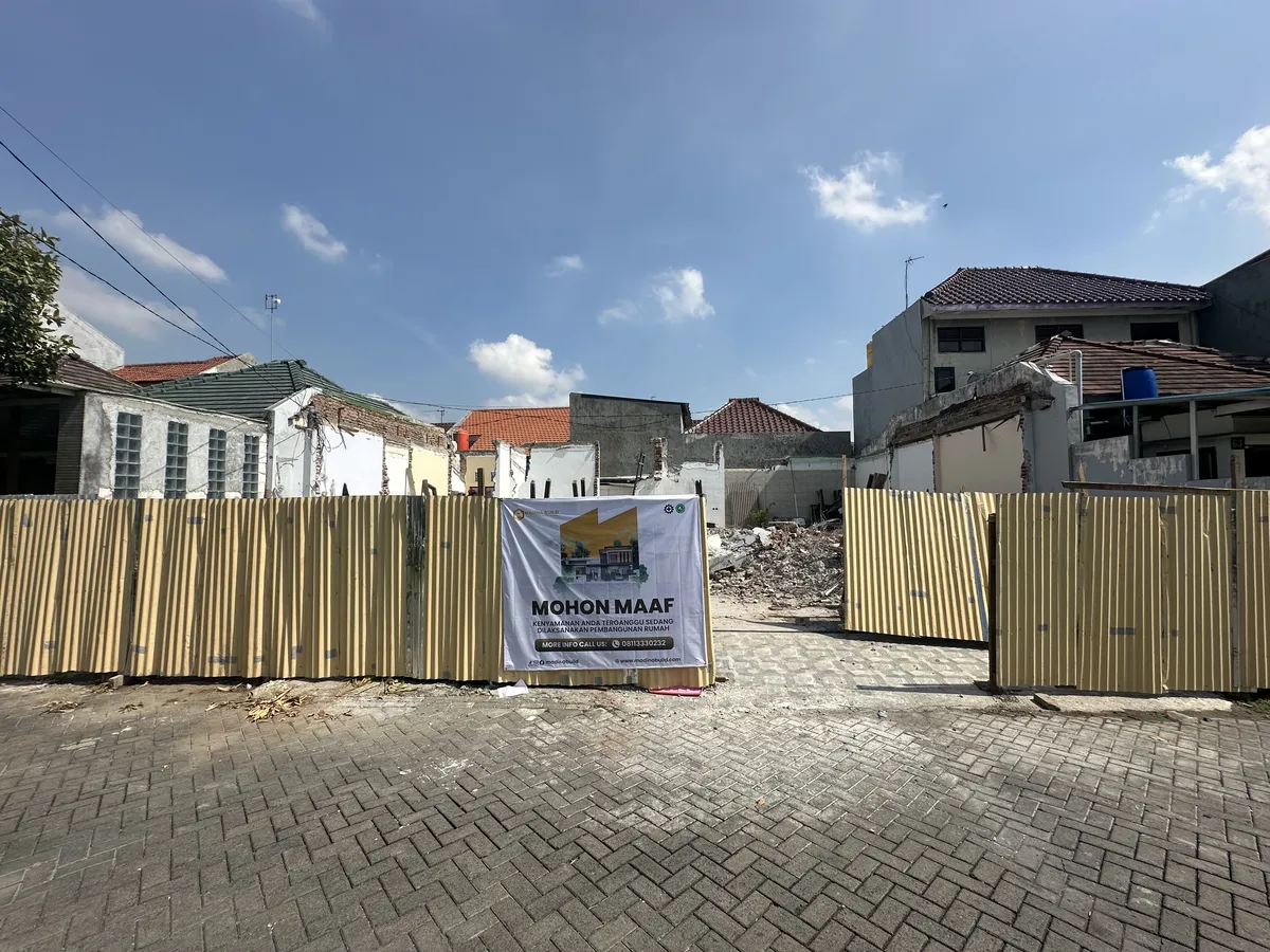 Lahan bekas bongkaran rumah lama dipagar seng dengan spanduk pemberitahuan pembangunan dari Madina Build untuk warga sekitar